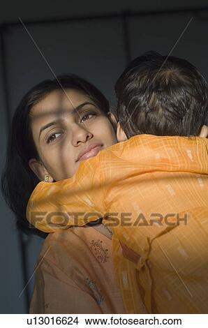 Picture - Close-up of a mother hugging her son. Fotosearch