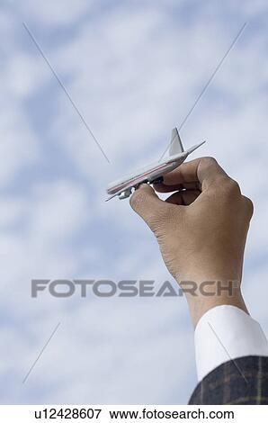 Stock Photo - Close-up of a person's hand holding a model airplane. Fotosearch