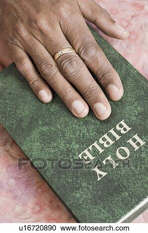 Close-up of a person's hand on the Bible View Large Photo Image Stock Image - Close-up of a person's hand on the Bible. Fotosearch