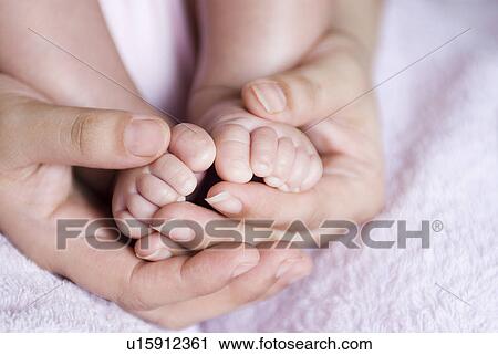 Close-up of a person's hands holding a baby's feet View Large Photo Image Stock Image - Close-up of a person's hands holding a baby's feet. Fotosearch