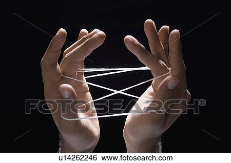 Close-up of a person's hands playing cats cradle with a rubber band View Large Photo Image Stock Photograph - Close-up of a person's hands playing cats cradle with a rubber band. Fotosearch