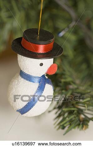Stock Photo - Close-up of a snowman hanging on a Christmas tree. Fotosearch