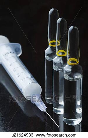 Stock Image - Close-up of a syringe with three vials. Fotosearch