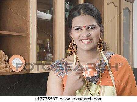Stock Photo - Close-up of a teenage girl holding a tea cup and smiling. Fotosearch
