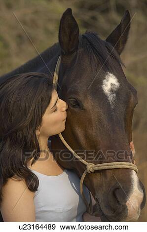 Close-up of a teenage girl kissing a horse View Large Photo Image Stock Photo - Close-up of a teenage girl kissing a horse. Fotosearch