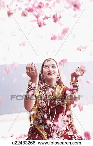 Stock Photograph - Close-up of a teenage girl wearing traditional clothes and scattering rose petals. Fotosearch