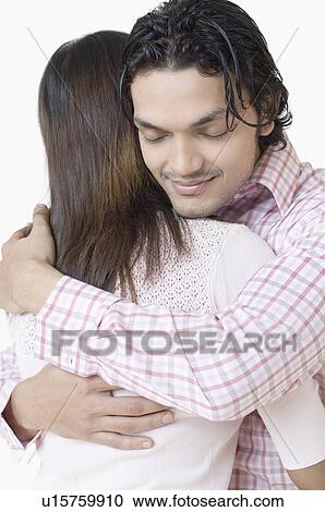 Stock Image - Close-up of a young couple embracing each other. Fotosearch
