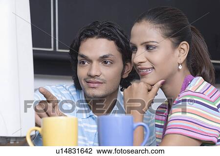 Close-up of a young man and a young woman working on a computer in the office View Large Photo Image Stock Image - Close-up of a young man and a young woman working on a computer in the office. Fotosearch