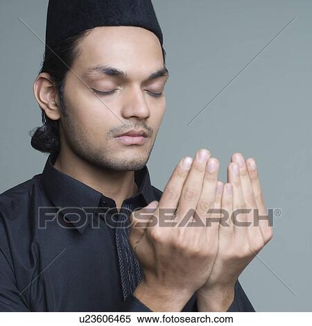 Stock Photography - Close-up of a young man praying. Fotosearch