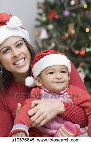 Close-up of a young woman carrying her son View Large Photo Image Stock Photography - Close-up of a young woman carrying her son. Fotosearch