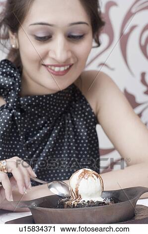 Close-up of a young woman eating an ice cream View Large Photo Image Stock Image - Close-up of a young woman eating an ice cream. Fotosearch