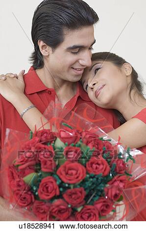 Stock Image - Close-up of a young woman embracing a young man. Fotosearch