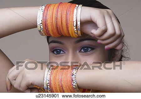 Stock Image - Close-up of a young woman holding her arms in front of her face. Fotosearch