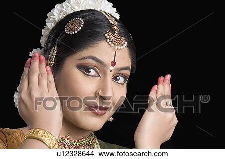 Picture - Close-up of a young woman performing Bharatnatyam. Fotosearch