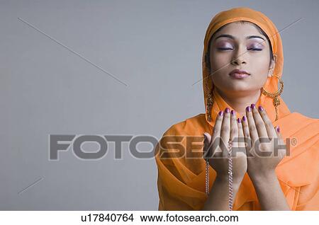 Close-up of a young woman praying View Large Photo Image Picture - Close-up of a young woman praying. Fotosearch
