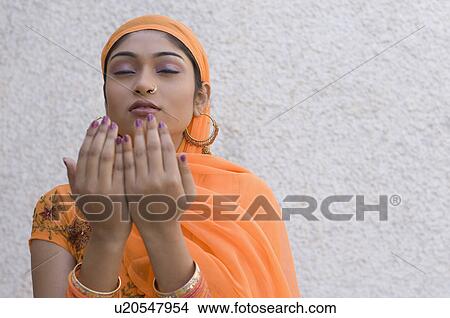 Picture - Close-up of a young woman praying. Fotosearch