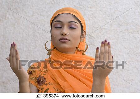 Close-up of a young woman praying View Large Photo Image Picture - Close-up of a young woman praying. Fotosearch