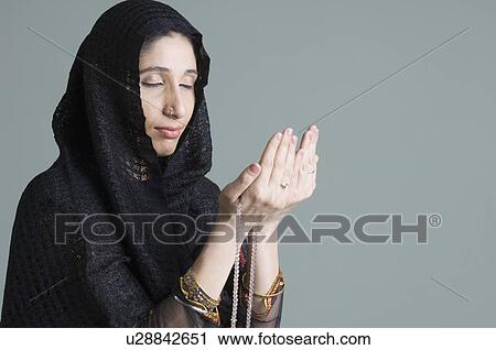 Close-up of a young woman praying View Large Photo Image Stock Image - Close-up of a young woman praying. Fotosearch