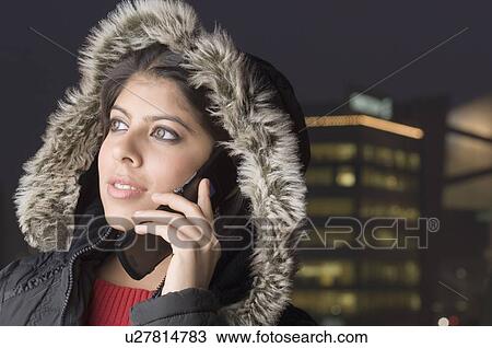 Close-up of a young woman talking on a mobile phone View Large Photo Image Stock Image - Close-up of a young woman talking on a mobile phone. Fotosearch