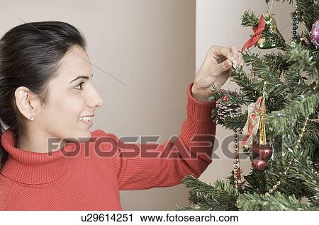 Close-up of a young woman touching a Christmas tree View Large Photo Image Stock Image - Close-up of a young woman touching a Christmas tree. Fotosearch