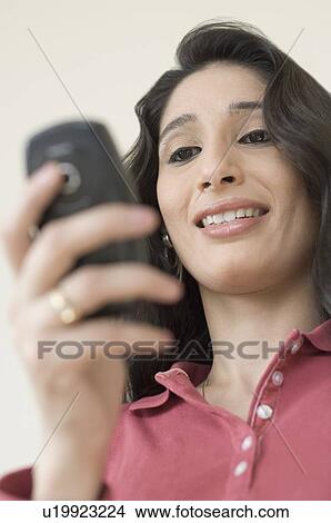 Picture - Close-up of a young woman using a mobile phone. Fotosearch