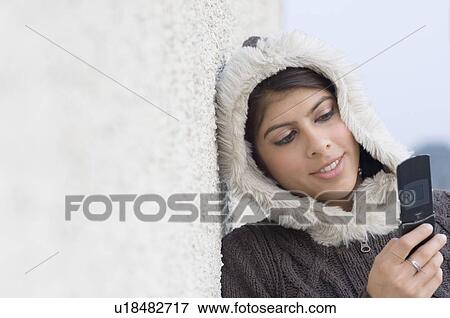 Stock Photo - Close-up of a young woman using a mobile phone. Fotosearch