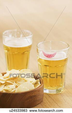 Close-up of beer glasses and a bowl of potato chips View Large Photo Image Stock Image - Close-up of beer glasses and a bowl of potato chips. Fotosearch