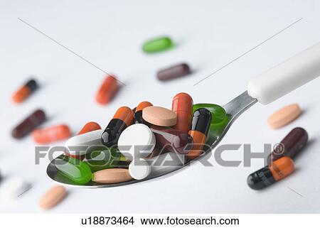 Picture - Close-up of capsules and tablets in a spoon. Fotosearch