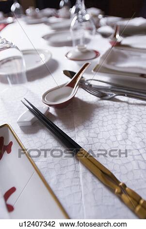 Stock Image - Close-up of chopsticks and crockery on a dining table. Fotosearch