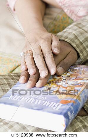 Close-up of couple's hands on the Bhagavad-Gita View Large Photo Image Stock Photo - Close-up of couple's hands on the Bhagavad-Gita. Fotosearch