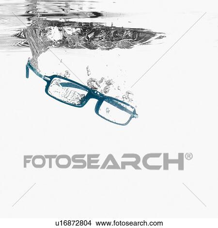 Picture - Close-up of eyeglasses underwater. Fotosearch