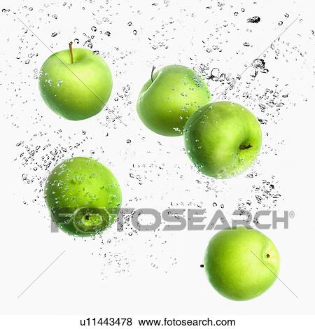 Stock Photo - Close-up of five green apples in water. Fotosearch