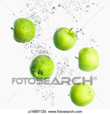 Stock Photography - Close-up of five green apples in water. Fotosearch