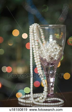 Stock Photo - Close-up of pearl necklaces in a wine glass. Fotosearch