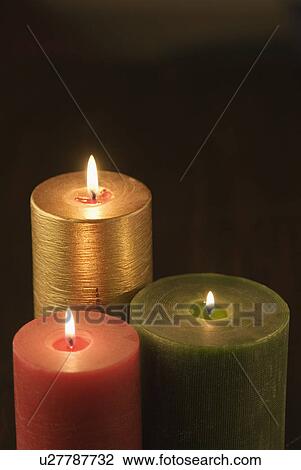 Stock Image - Close-up of three burning candles. Fotosearch