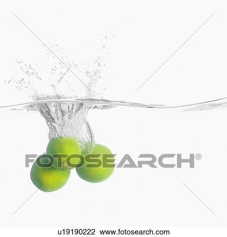 Stock Image - Close-up of three lemons underwater. Fotosearch