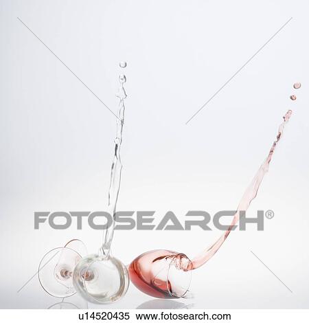 Stock Photography - Close-up of wine spilling from two wine glasses. Fotosearch