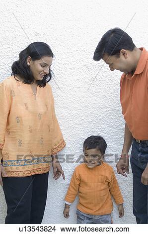 Couple standing with their son View Large Photo Image Picture - Couple standing with their son. Fotosearch