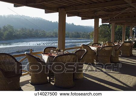 Stock Image - Empty chairs and a table in a restaurant. Fotosearch