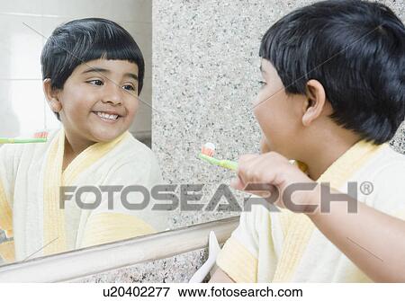 Girl holding a toothbrush looking at a mirror View Large Photo Image Stock Photo - Girl holding a toothbrush looking at a mirror. Fotosearch