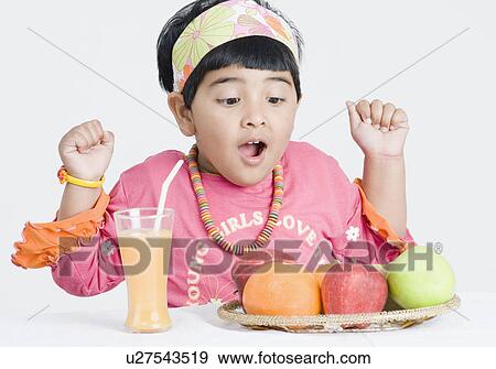Girl looking at a platter of fruit with excitement View Large Photo Image Stock Photo - Girl looking at a platter of fruit with excitement. Fotosearch