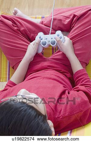 High angle view of a boy playing video game View Large Photo Image Picture - High angle view of a boy playing video game. Fotosearch