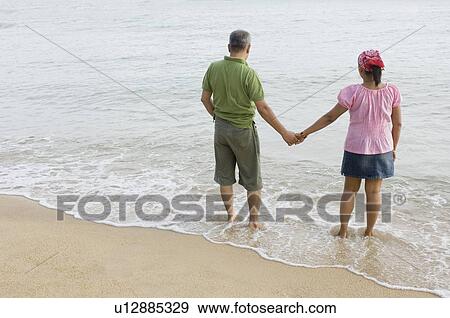 High angle view of a mid adult couple holding hands on the beach View Large Photo Image Stock Photo - High angle view of a mid adult couple holding hands on the beach. Fotosearch
