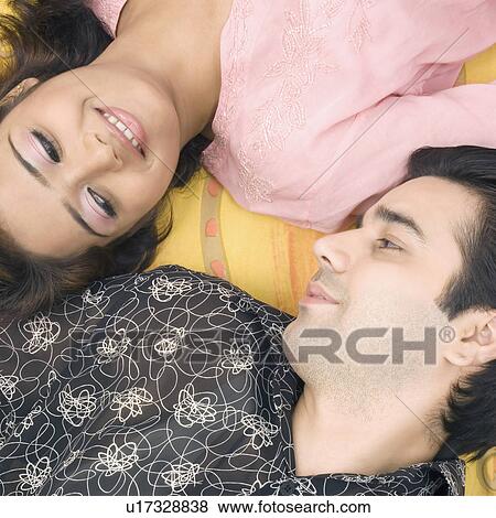 High angle view of a young couple looking at each other and smiling View Large Photo Image Stock Photo - High angle view of a young couple looking at each other and smiling. Fotosearch