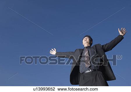 Low angle view of a businessman with his arms outstretched View Large Photo Image Stock Image - Low angle view of a businessman with his arms outstretched. Fotosearch