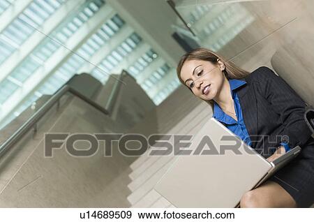 Low angle view of a businesswoman using a laptop View Large Photo Image Stock Photo - Low angle view of a businesswoman using a laptop. Fotosearch