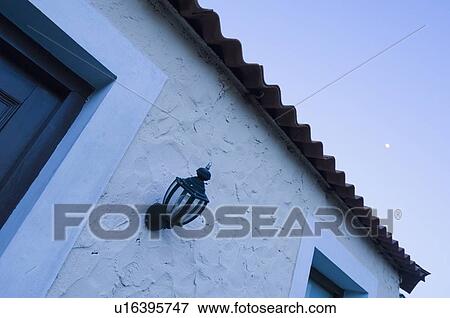 Stock Photo - Low angle view of a lamp on the wall of a house. Fotosearch