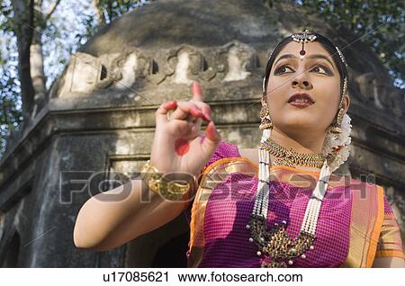 Low angle view of a young woman dancing View Large Photo Image Stock Image - Low angle view of a young woman dancing. Fotosearch
