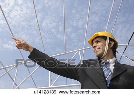 Stock Photo - Low angle view of an architect at a construction site. Fotosearch
