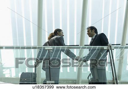 Stock Photo - Low angle view of two businessmen shaking hands. Fotosearch